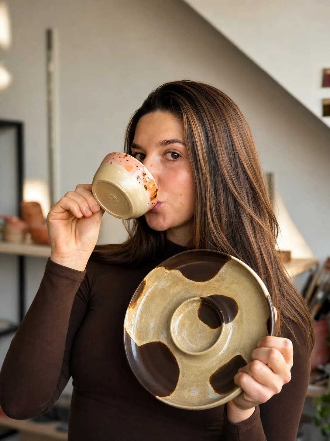 Vera drinkt uit een zelfgemaakte mok, met een bord in haar hand