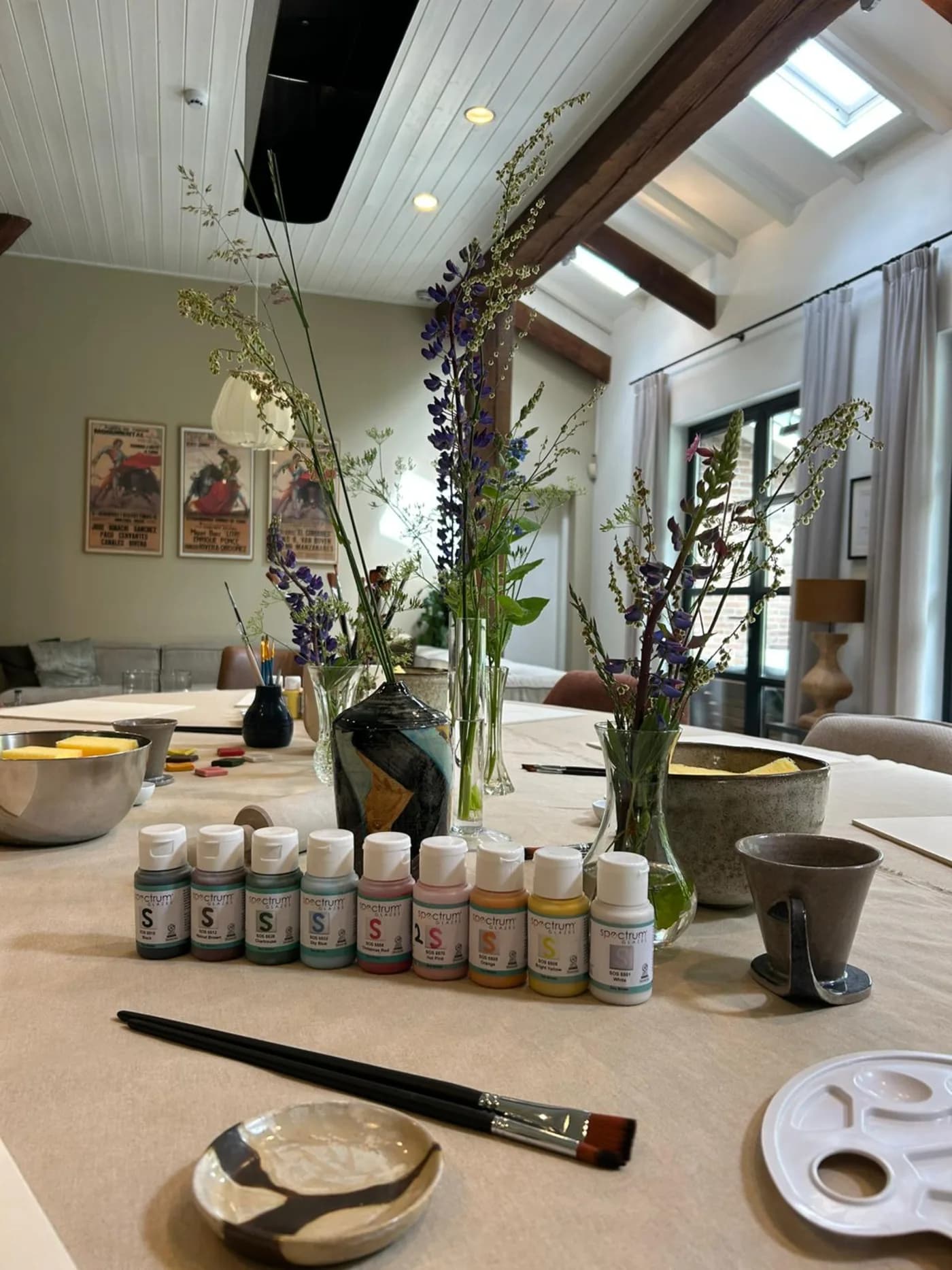 Glazuren en een penseel klaargezet op de werktafel in het atelier